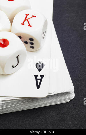 Würfeln und Karten-Poker-Spiel auf einem schwarzen Hintergrund. Vertikal Stockfoto