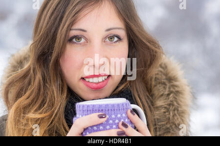 Mädchen mit Tasse Tee an einem kalten verschneiten Wintertag Stockfoto