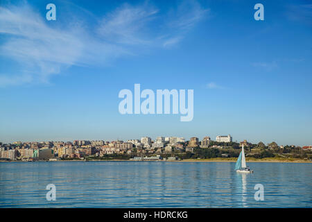 Segelboot bei Sonnenuntergang am Santander Bucht. Im Hintergrund der Stadt zu sehen, aus dem Dorf de Pedreña, Kantabrien, Spanien, Europa Stockfoto