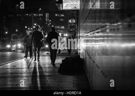 Obdachloser schläft rau, während Leute in Leeds, West Yorkshire, England vorbeigehen Stockfoto