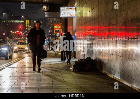 Obdachloser schläft rau, während Leute in Leeds, West Yorkshire, England vorbeigehen Stockfoto