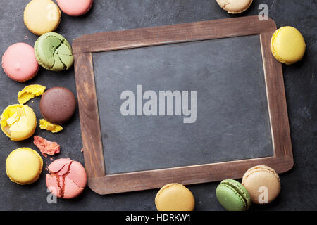 Bunte Makronen und Blackboard. Süßen Macarons am Steintisch. Draufsicht mit textfreiraum für Ihren text Stockfoto