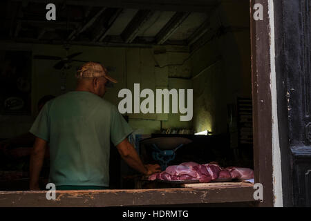 Mann mit Fleisch auf Verkauf im Shop auf San Ignacio, Havanna Vieja, La Havanna, Kuba. Stockfoto