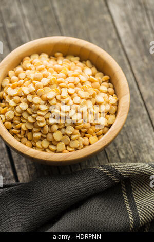 Gelbe Erbsen in Schüssel auf Holztisch. Stockfoto