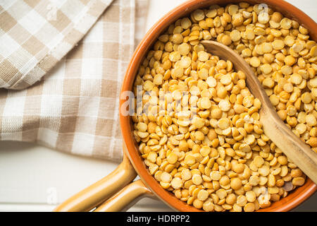 Gelbe Erbsen in Schüssel auf Holztisch. Ansicht von oben. Stockfoto