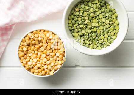 Grüne und gelbe Erbsen in Schüssel geben. Ansicht von oben. Stockfoto