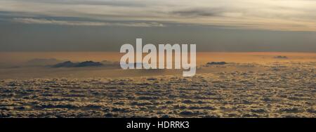 Blick auf Berge über Wolken auf Inseln über das Rote Meer während des Sonnenuntergangs. Stockfoto