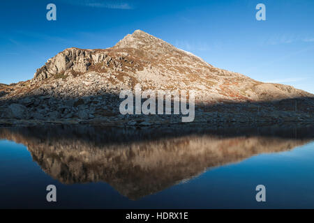 Berg gegen blauen Himmel spiegelt sich in der Oberfläche des Sees Stockfoto