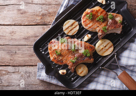 Gegrilltes Schweinefleisch Steak mit Zwiebel in einer Pfanne Grill, horizontale Ansicht von oben Stockfoto