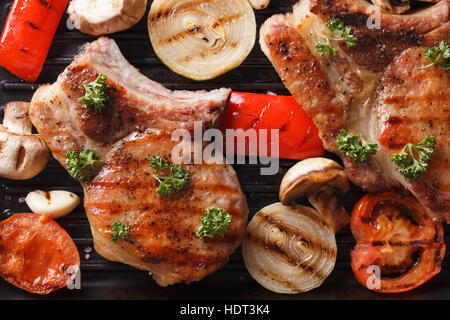 Schweinesteak gegrillt mit Zwiebeln und Tomaten Nahaufnahme. horizontale Ansicht von oben Stockfoto