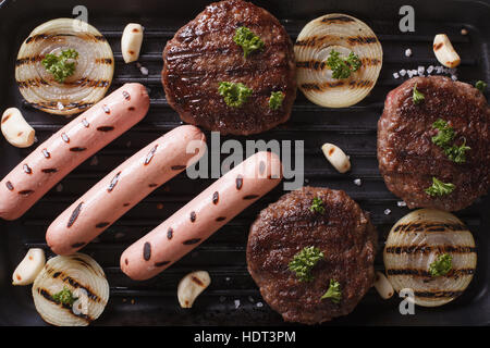 gegrillte Burger und Würstchen auf dem Grill hautnah. horizontale Ansicht von oben Stockfoto