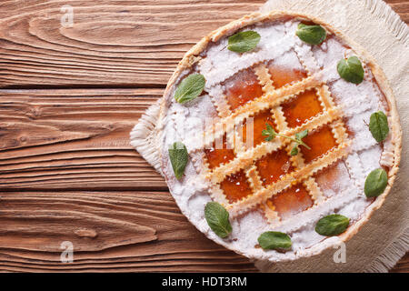 Leckere italienische Torte mit Marillenmarmelade und Minze auf einem Holztisch. horizontale Ansicht von oben Stockfoto
