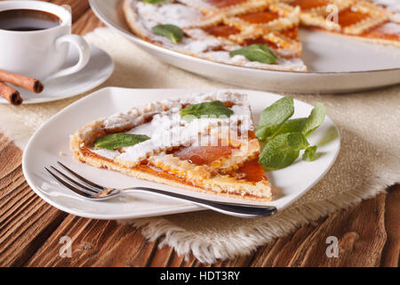 Stück des italienischen Torte mit Marillenmarmelade und Kaffee auf dem Tisch. horizontale Stockfoto