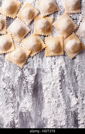 Italienische ungekochten Ravioli mit Mehl auf dem Tisch. vertikale Ansicht von oben Stockfoto