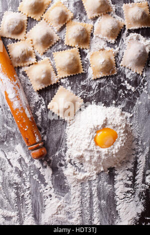 Italienische Ravioli mit rohen Zutaten auf den Tisch. vertikale Ansicht von oben Stockfoto