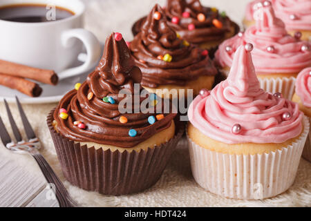 Leckere Muffins mit Buttercreme und Kaffee auf dem Tisch. Horizontale Nahaufnahme Stockfoto