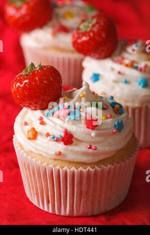 Leckere Muffins mit Sahne und frischen Erdbeeren hautnah. vertikale Stockfoto