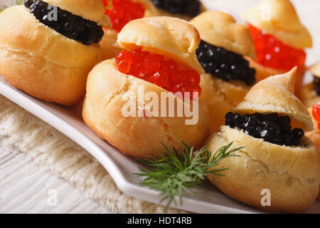 Frischen Windbeutel gefüllt mit roten und schwarzen Kaviar auf eine Platte Nahaufnahme. Horizontale Stockfoto
