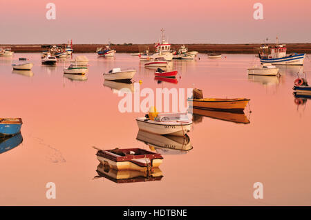 Fischerboote ankern in den ruhigen Gewässern des Ria Formosa Lagune in der Dämmerung Stockfoto