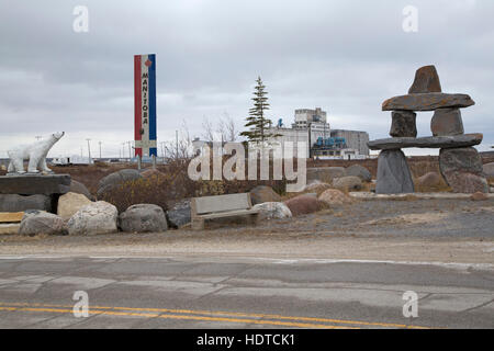 Ein Eisbär-Statue und ein Inukshuk in der Nähe von Port Churchill in Churchill, Manitoba, Kanada. Stockfoto