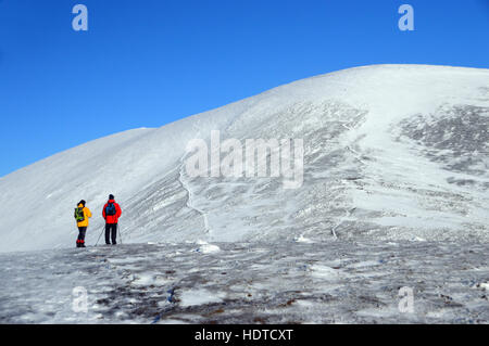 Zwei Wanderer auf dem Gipfel des Carl Side blickt Skiddaw im Winter, Nationalpark Lake District, Cumbria, UK. Stockfoto