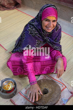 Traditionell gekleidete alte omanischen Frau Sandale Holzöl mit ihren Händen machen. Stockfoto