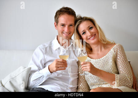 Mann, Frau, paar auf Sofa, in der Liebe, Wein, Glas, Blick in die Kamera Stockfoto