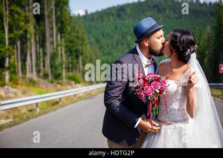 frisch verheiratete Paar küssen auf der Straße Stockfoto