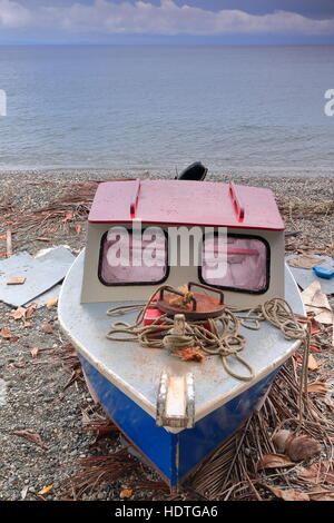Alte lokale Außenborder Motorboot mit Liegeplatz Seile und rostiges Eisen, Runde Anker über Palme gestrandet am steinigen Strand von Panngi Dorf verlässt, lösen Stockfoto