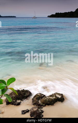 Weiße Luxus-Katamaran verankert vor am weißen Sandstrand von Lonnoc Strand mit Blick auf Elephant Island über das blaue Wasser des Hog Hafenbucht. Espiritu Stockfoto