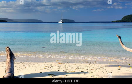 Weiße Luxus-Katamaran verankert vor am weißen Sandstrand von Lonnoc Strand mit Blick auf Elephant Island über das blaue Wasser des Hog Hafenbucht. Espiritu Stockfoto