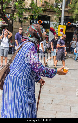 Muslimische ältere Frau Bettler gekleidet in eine Burka Betteln auf einem Platz in Barcelona, Spanien Stockfoto