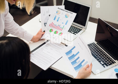Business team analyzing income graphs with modern laptop computers. Close up analysis and strategy concept. Stockfoto