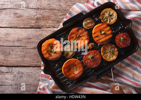 Kürbis, Tomaten, Zwiebeln und Zitronen auf dem Grill schwenken. horizontale Ansicht von oben Stockfoto