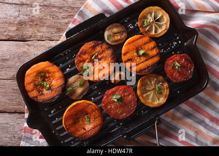 Kürbis, Tomaten, Zwiebeln und Zitronen auf dem Grill schwenken. horizontale Ansicht von oben closeup Stockfoto