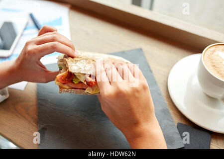 Frau essen Lachs Panini Sandwich Restaurant Stockfoto