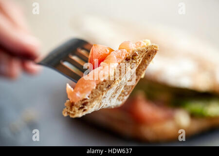 Person essen Lachs Panini Sandwich Restaurant Stockfoto