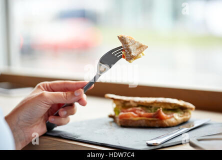 Frau essen Lachs Panini Sandwich Restaurant Stockfoto