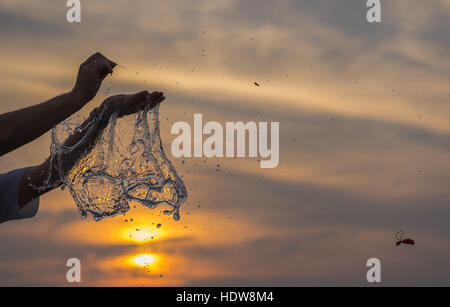 Wasser-Ballon-Explosion vor einem Sonnenuntergang Himmel. Stockfoto