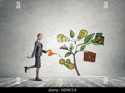 Junge Geschäftsfrau in leeren Raum Gießen gezeichnete Wachstumskonzept mit can Stockfoto