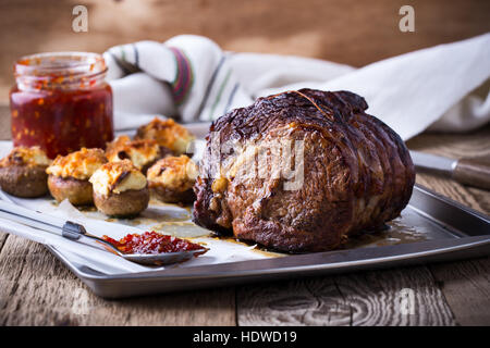 Hausgemachte Ribeye ohne Knochen Roastbeef mit gefüllte Champignons auf Backblech Stockfoto