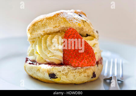 Scone Sahne und Erdbeeren auf einem Teller mit der Gabel. Stockfoto