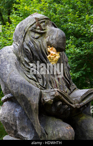 Huhn-of-the-Woods Pilz (Laetiporus Sulphureus) eine hölzerne Statue entwachsen. Llandrindod Wells, Powys, Wales. August. Stockfoto