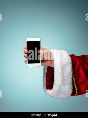 Santa Claus halten Handys bereit für Weihnachten auf blauen Studio-Hintergrund Stockfoto