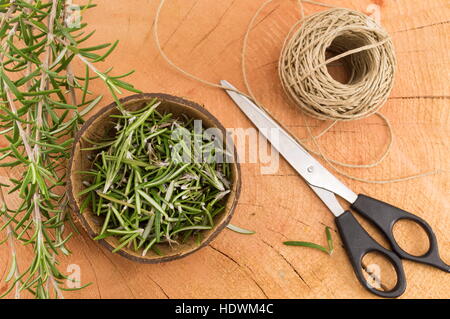 Rosmarin in einer Kokosnussschale mit einem paar der Schere und ein Seil Stockfoto