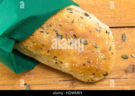 selbstgebackenes Brot mit Samen auf einem Holztisch Stockfoto