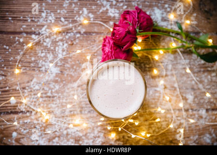 Tasse Kaffee mit Makronen und Rosen auf Holztisch Stockfoto