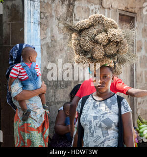 Afrikanische Frau mit Besen auf Kopf Stockfoto