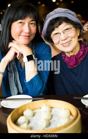 Ältere japanische Mutter und Tochter lächelnd in restaurant Stockfoto