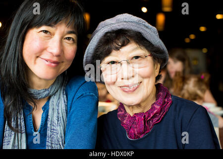 Ältere japanische Mutter und Tochter lächelnd in restaurant Stockfoto